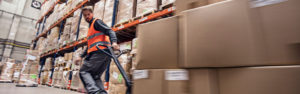 Employee pulling a pallet of boxes through a warehouse